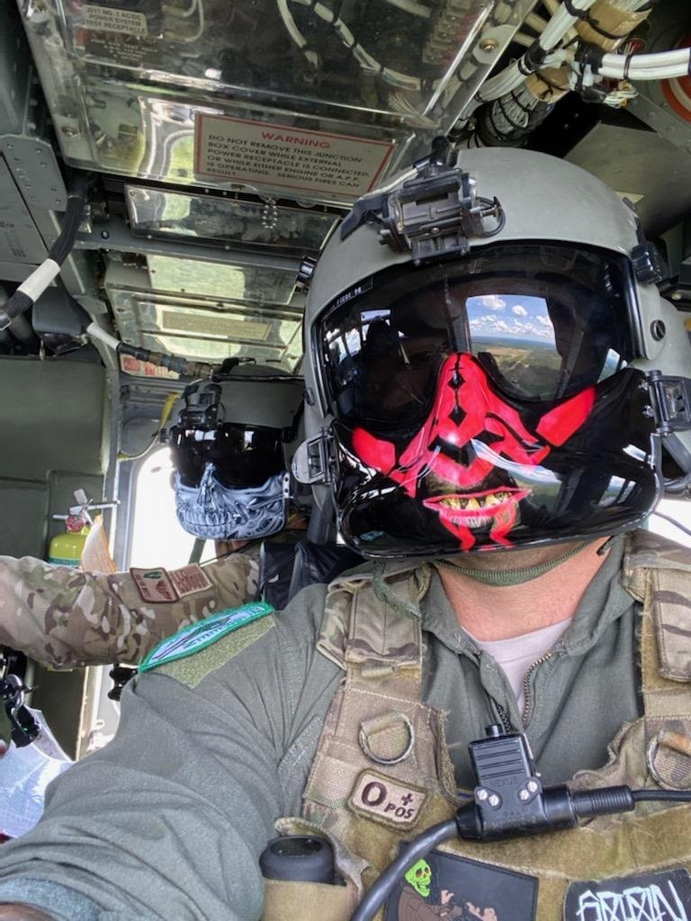 Two Soldiers in a Helicopter, Each With Airbrushed Masks.