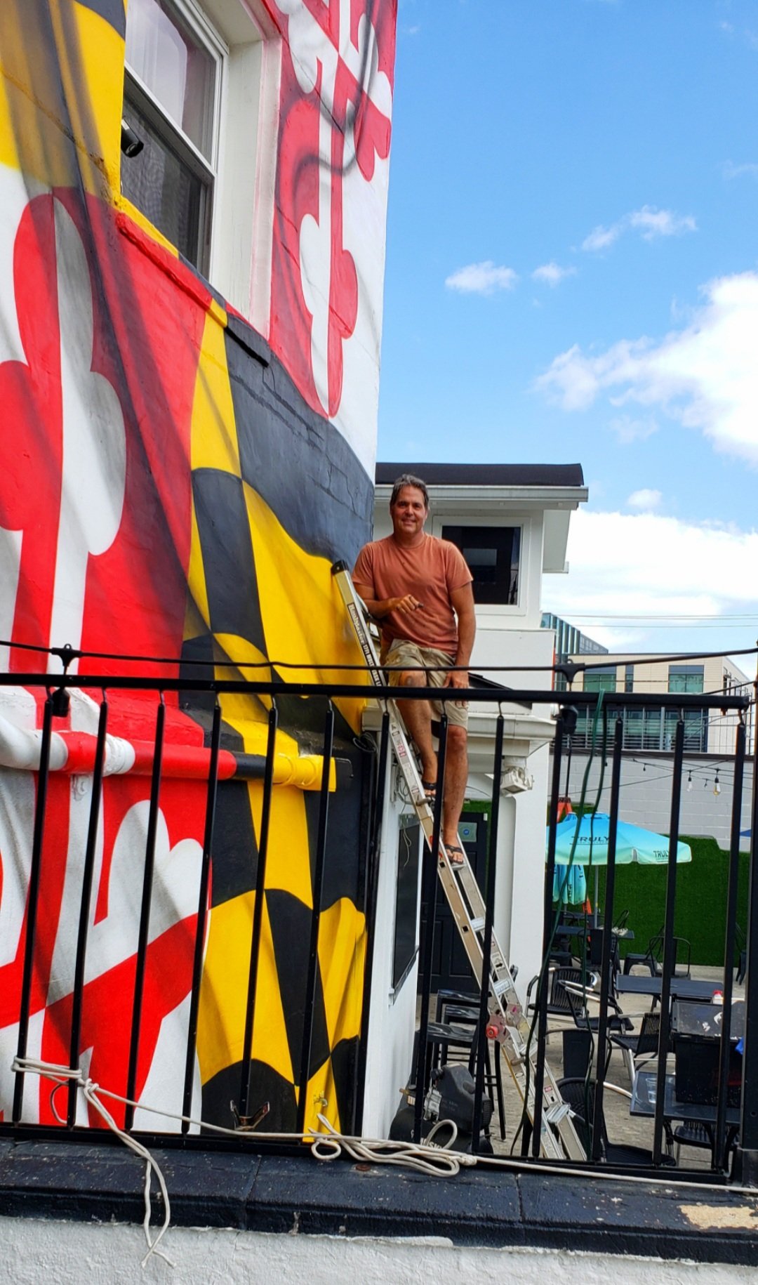 Mural Art of Peter Frechette Painting Maryland Flag on Building.